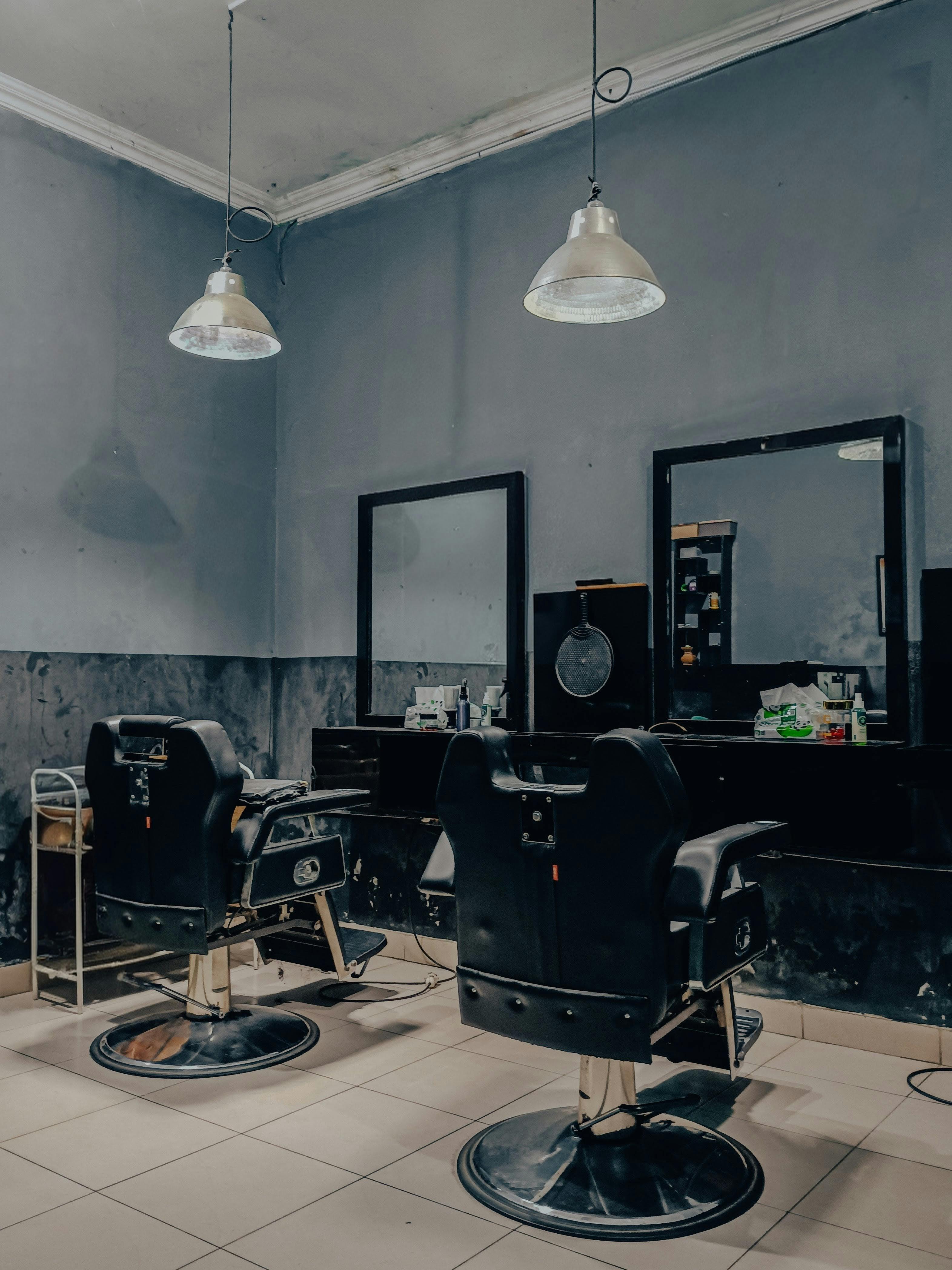 Dark barbershop interior with clean chairs and mirrors